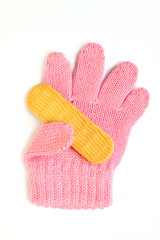Children's glove holds cracker cookies. Little pink winter accessory for a girl on a white background. Food for little kids. Tasty sweet cookies for babies. Healthy eating concept for baby.