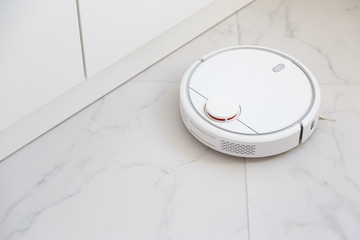 Robot vacuum cleaner vacuuming tiles in room