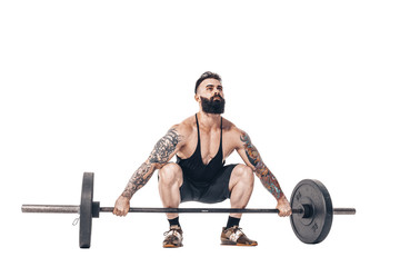 The technique of doing an exercise of deadlift with a barbell of a young muscular strong tattooed bearded sports men on a white studio background. Isolate