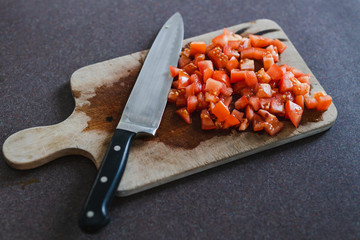 diced tomatoes with knife on cutting board