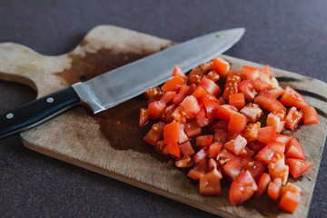 diced tomatoes with knife on cutting board