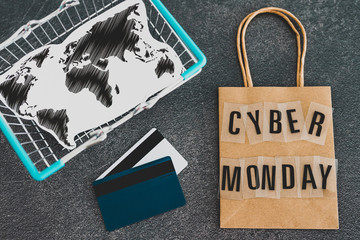cyber monday shopping bag with payment cards and world map insie shopping basket
