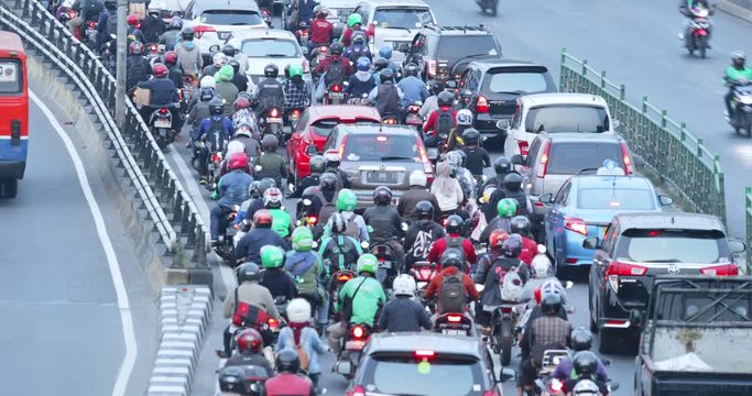 JAKARTA, Indonesia - November 27, 2019: Aerial view of numerous motorcycle and cars moving in traffic jam on rush hour at highway. Shot in 4k resolution from a drone