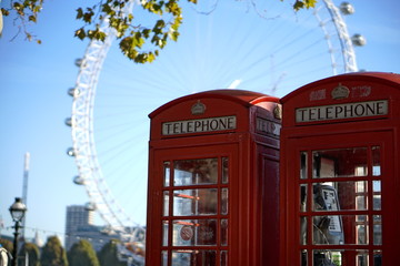 red telephone box in london with london eye in the background