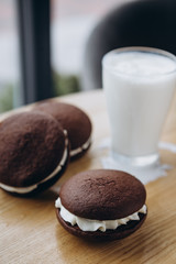 Close up Traditional chocolate and Pumpkin Whoopie pies filled made with vanilla cream cheese frosting cream