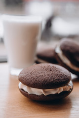 Close up Traditional chocolate and Pumpkin Whoopie pies filled made with vanilla cream cheese frosting cream
