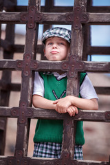 Obraz premium Young boy is inside a cage hanging down pose for fun at a middle age festival