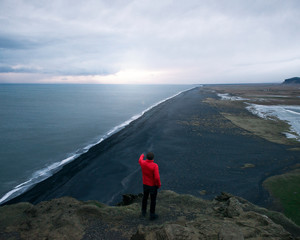 hombre arriba de la colina mirando al mar en islandia