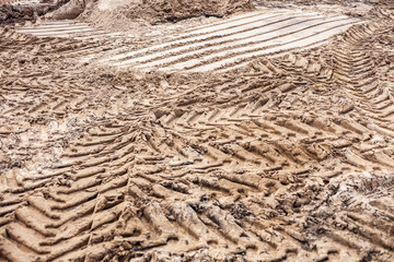 Sand texture at a construction site. Traces of wheels.