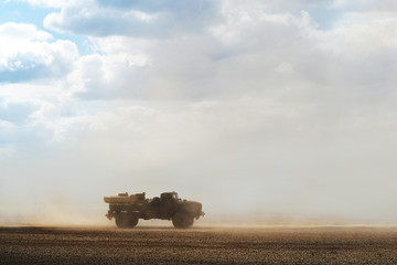 Fototapeta premium Truck in the desert during a dust storm. Desert storm, sandstorm