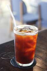 Black coffee with ice on table in cafe.