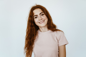 Obraz premium schoolgirl with a smile of joyful admiration looks at the camera, her beautiful teeth are visible, gorgeous hair is disheveled on the shoulders