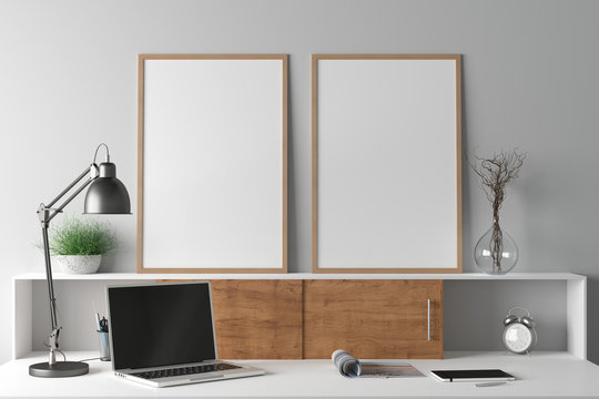 Workspace with two vertical poster mock ups on the desk. Desk with drawers in interior of the studio or at home with white wall. Clipping path around poster. 3d illustration.