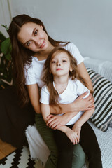 an older sister is smiling holding a younger one in her arms.