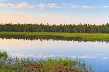 Beautiful and peaceful small lake surrounded by swamps in Finland