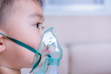 Closeup asian face little children boy using steam inhaler nebulizer mask inhalation