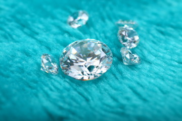 Close up shoot of diamonds on a green furry fabric as a backgound