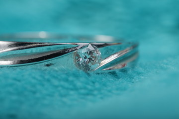 Close up shoot of an white gold engagement ring with diamonds on an isolated green background