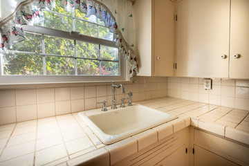 Vintage kitchen sink and counter with old tile. 

