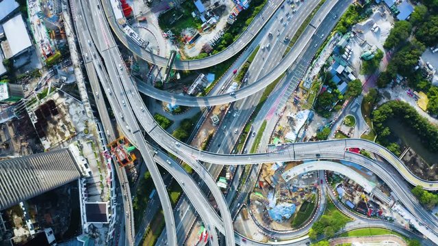 KUALA LUMPUR, Malaysia - November 28, 2019: B-roll top down view of fast traffic on freeway intersection bridge in Kuala Lumpur city. Shot in 4k resolution from a drone flying forwards