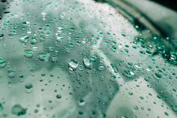 Clean car windshield with multiple water drops on after heavy rain and dew water repellent surface...