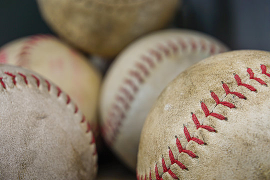 Close up image of old baseballs in a bin