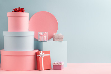 Pink and turquoise round gift boxes and red fir tree on teal background