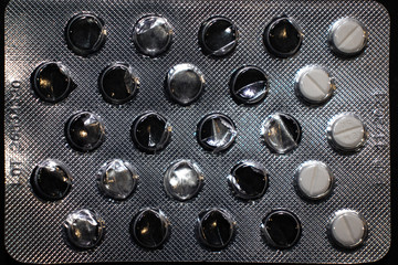 Perscription drugs under blue light in plastic metal wrapper