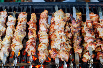 Grilled kebab cooking on skewers. Grill with charcoal and flame.
