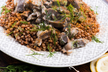 Stewed turkey stomachs with vegetables and buckwheat in a bowl