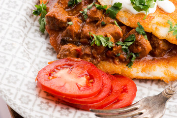 Potato pancakes with meat, vegetable, tomato and parsley