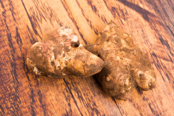 Raw Whole ans sliced Jerusalem artichokes on a cutting board