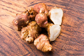 Raw Whole ans sliced Jerusalem artichokes on a cutting board