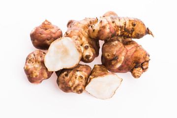 Raw Whole ans sliced Jerusalem artichokes on a white background