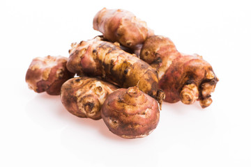 Raw Whole ans sliced Jerusalem artichokes on a white background