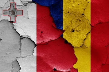 flags of Malta and Romania painted on cracked wall