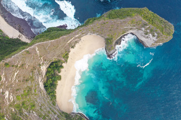 Aerial view of the Kelingking Beach aka Manta Bay with the amazing big wave and blue ocean located in Nusa Penida, Bali, Indonesia.