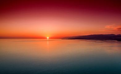 Fototapeta premium Sunset over a calm sea from the height of bird flight