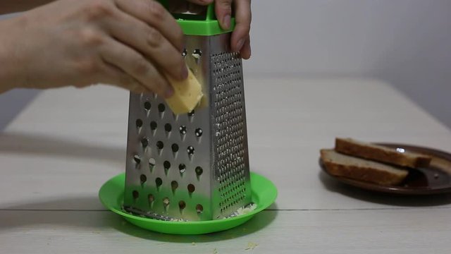 Hands grating cheese. Close-up footage.