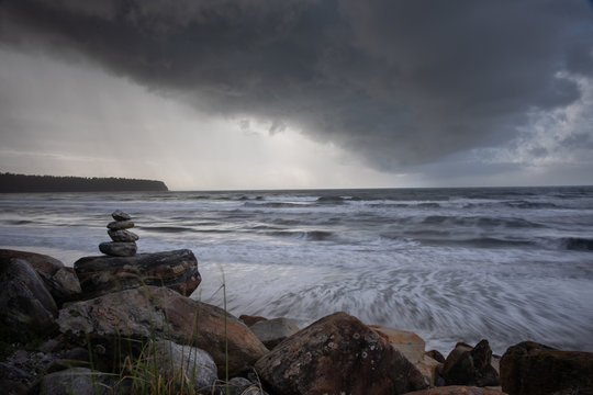 Balanced stone stacks against a stormy seascape