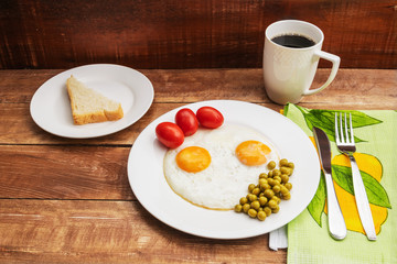 Two fried eggs with a green pot and tomatoes for a healthy breakfast.