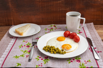Two fried eggs with a green pot and tomatoes for a healthy breakfast.