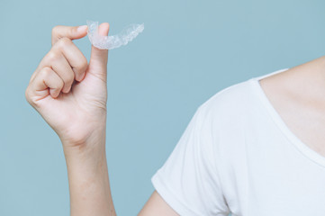Woman show orthodontic silicone trainer. Mobile orthodontic appliance for dental correction. tooth whitening systems.