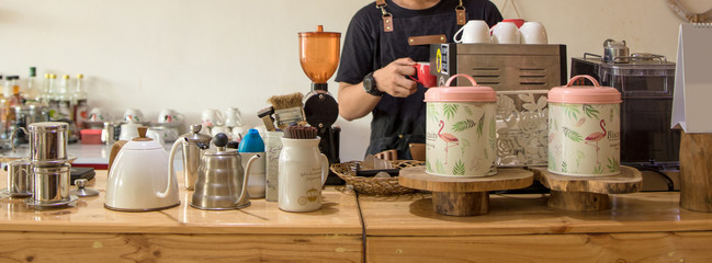 portrait of handsome asian barista inside cafe counter doing his job making a coffee latte