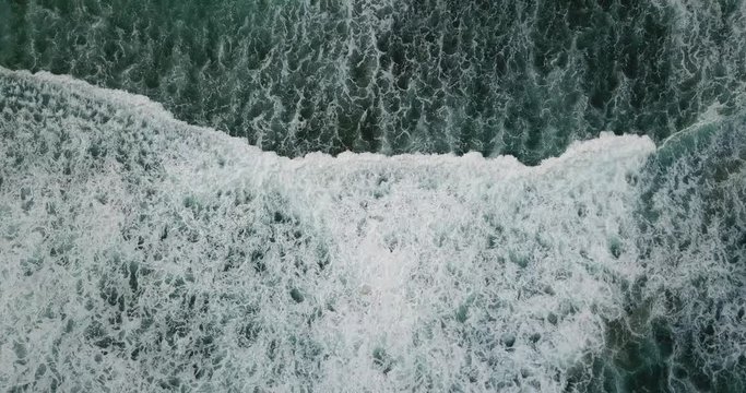 Spinning drone shot of waves breaking underneath beach in Puerto Rico