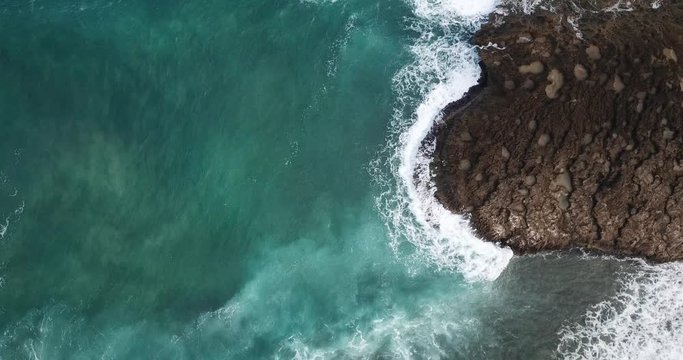 Aerial shot of waves crashing on rocks in Jobos Beach Puerto Rico
