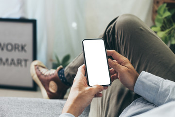 Mockup image blank white screen cell phone.men hand holding texting using mobile on desk at home office. background empty space for advertise text.people contact marketing business and technology 