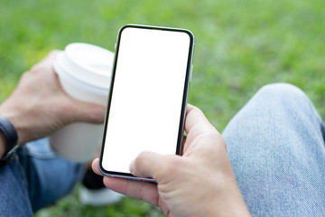 Mockup image blank white screen cell phone.men hand holding texting using mobile sitting in park.background empty space for advertise text.people contact marketing business and technology 