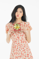 Photo of asian curious woman in red dress rejoicing her birthday or new year gift box. Young woman holding gift  box with red bow being excited and surprised  holiday.