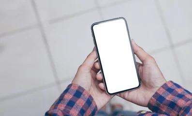 Fotobehang Mockup image blank white screen cell phone.men hand holding texting using mobile  background empty space for advertise text.people contact marketing business and technology  © panitan